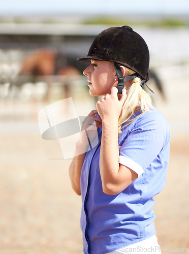 Image of Woman prepare, horse jockey and helmet of young athlete on equestrian training ground for show and race. Outdoor, female person and equipment fixing on animal farm for dressage with rider and horses