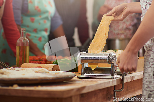 Image of Food, fresh pasta with hands of woman at kitchen counter and with people in family restaurant. Cooking or bakery, rolling pin and female person with pastry machine preparing pizza or cooking dough