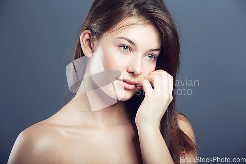 Image of Face, beauty and portrait of a innocent woman in studio with a glow, makeup and cosmetics. Headshot of aesthetic female model on a grey background for natural shine, hair care and facial dermatology