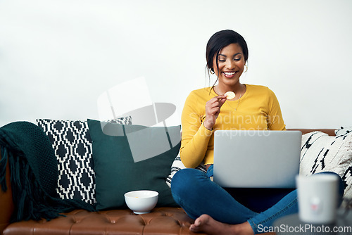 Image of Sofa, laptop and woman eating chips for movie, video streaming service or subscription at home. Happy african person watch film with potato chip, computer and internet connection on living room couch