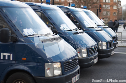 Image of Street, city and row of police vans for a public service and safety during a protest or march. Security, crime and law enforcement transport in a line as a barrier in urban town strike for protection