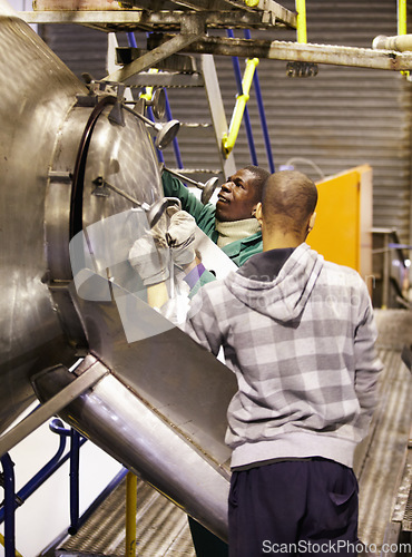 Image of Man winery worker, steel vat and checking on the winemaking process together in factory. Men working on wine maker on vats in cellar with metal tank in alcohol production or fermentation at warehouse