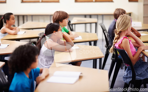 Image of Education, learning and children in classroom with focus, attention and study at Montessori school. Group of students at desk studying, child development and kids with concentration in lesson or test