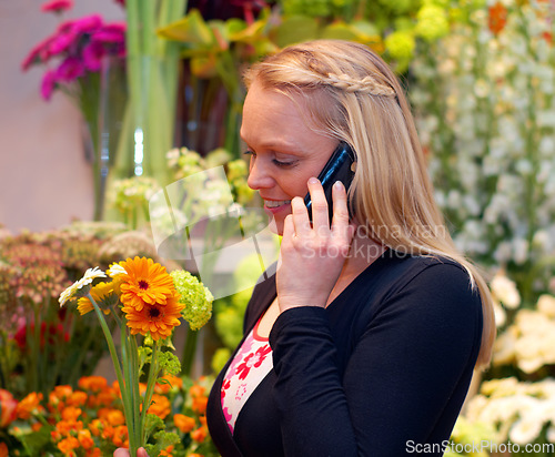 Image of Woman florist in shop with flowers, phone call and communication with small business contact. Female owner, customer and talking to flower supplier on mobile, botany industry or nursery on technology