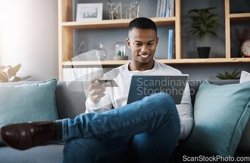 Image of Ecommerce, black man bank card and laptop in living room on sofa at his home. Online shopping, technology and happy African male person on couch with internet banking with digital device at house