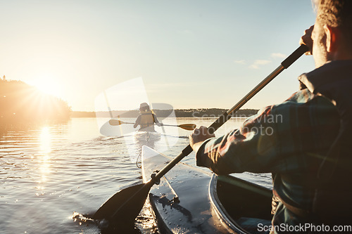 Image of Kayak, lake and people rowing a boat on the water during summer for recreation or leisure at sunset. Nature, view and horizon with people canoeing for adventure, freedom or travel while on vacation