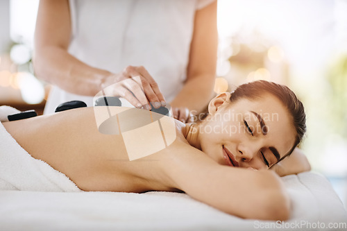 Image of Relax, hot stone and woman getting a back massage at a spa for luxury, calm and natural self care. Beauty, body care and tranquil female person sleeping while doing a rock body treatment at a salon.