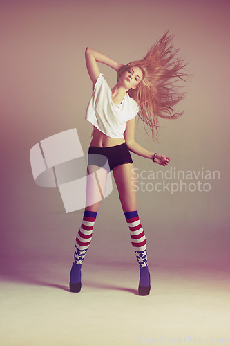 Image of Portrait of sexy woman dancing with socks, energy and retro fashion on studio background and American flag. Beauty, underwear and model or influencer shaking hair in vintage aesthetic mockup space.