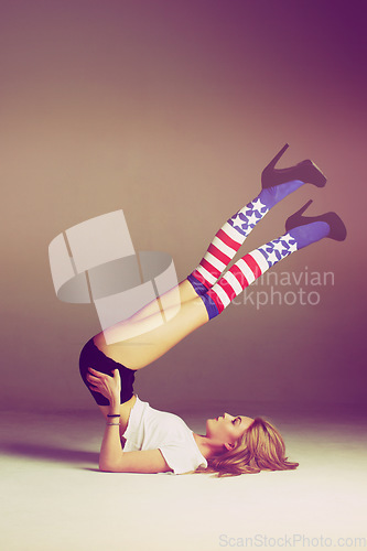 Image of Woman, usa fashion and socks of a model with flag legs and heels in air in studio. Isolated, young female person and gen z clothes with youth and carefree feeling relax with patriotic aesthetic