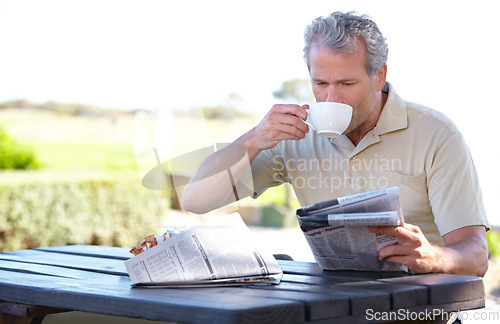 Image of Relax, coffee and newspaper with man in park for lunch break, summer and calm. News, nature and morning with senior person in outdoors reading at picnic table for retirement, tea and crossword