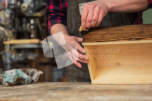 Image of Carpenter painting wooden