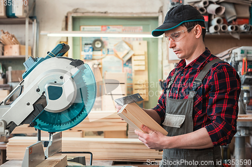 Image of Carpenter worker cutting wooden board