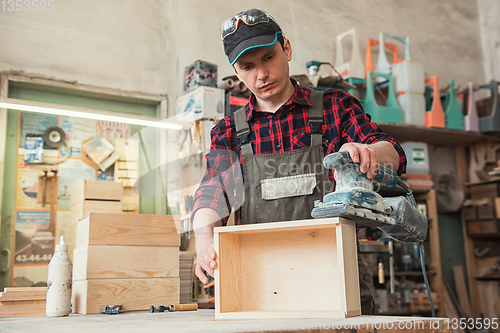 Image of Worker grinds the wood box