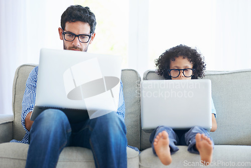 Image of Father, child and laptop working on sofa in living room together with technology and glasses at home. Dad, kid or little boy pretend to work in remote work on lounge couch with computer indoors