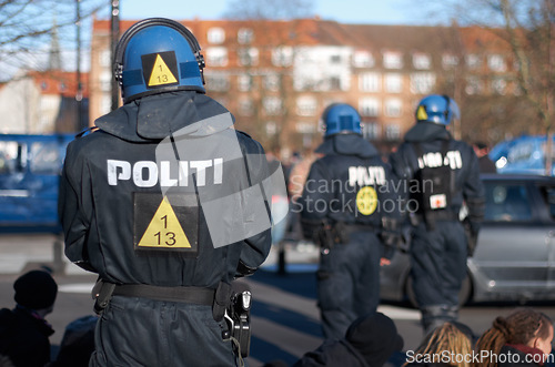 Image of Safety, peace and crowd control with police officer in city for law enforcement, protection or security. Brave, uniform and riot with person in Denmark street for rally, human rights or activist