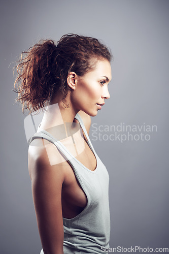 Image of Woman, curly hair and thinking in studio profile with beauty, wellness and healthy by gray background. Girl, model and isolated with fashion, clothes and think of idea, memory or remember by backdrop