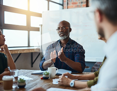 Image of Meeting, discussion and male manager with his team in the office planning a corporate project. Collaboration, teamwork and African mature businessman talking to colleagues in the workplace boardroom.