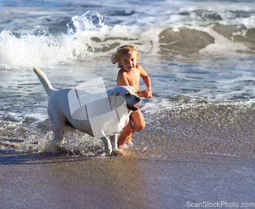 Image of Child, dog and beach with kid playing with pet animal running on sand by the ocean. Holiday, children and dogs swimming by the water with happiness and smile of a toddler on vacation with pets