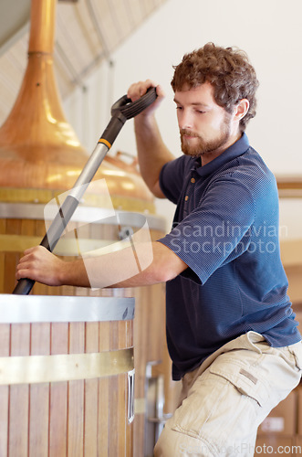 Image of Beer, factory and man manufacturing alcohol drink in the brewery industry or working on the fermentation process. Product, labour and young person making a craft in a storage or warehouse