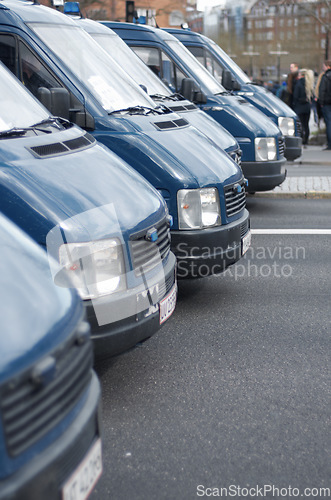 Image of Security, police and row of vans in the city for a public service during a protest or march. Safety, crime and law enforcement transport in a line as a barrier in an urban town strike for protection.