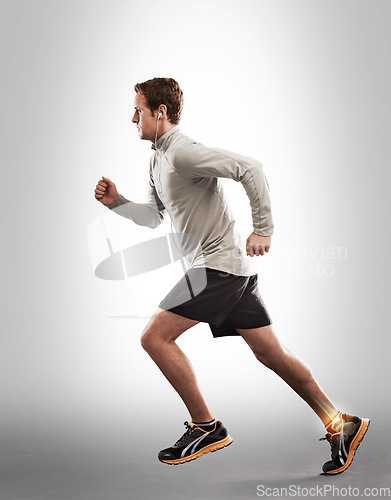 Image of Man running, fitness and ankle pain with overlay, exercise injury and medical emergency on studio background. X ray, anatomy and skeleton with male runner with injured foot, inflammation and sprain