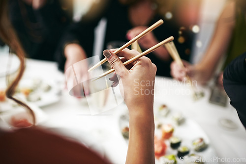 Image of Chopstick, dinner party and woman hand at a restaurant at a table with drinks. Asian meal, sushi and friends celebration event with food and social group with drink together at a Japanese dining bar