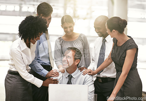 Image of Laptop, collaboration and achievement with a business team congratulating a male colleague in the office. Computer, proud or motivation with a group of colleagues working together to achieve success