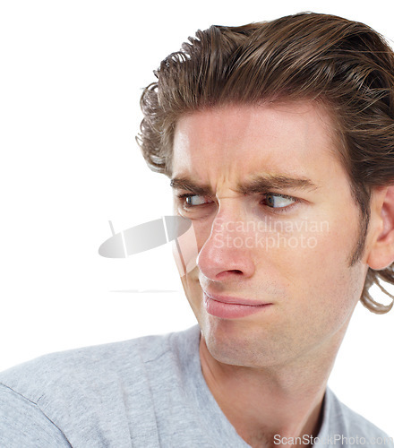 Image of Young man, disgust and face looking over shoulder with anger, confused or frown against a white studio background. Isolated male model with annoyed, angry or funny facial expression and smirk