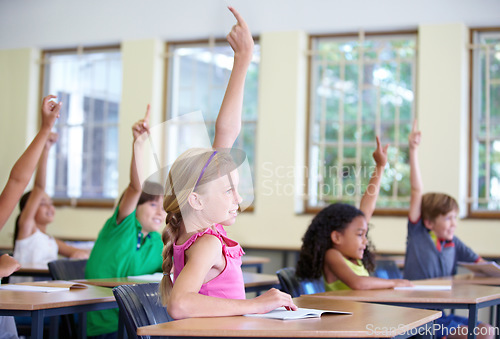 Image of Children, classroom and raise hands on school desk or excited kids learning for test and future information. Education, knowledge and table for asking or exam answer or growth and child development