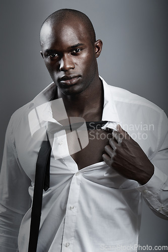 Image of Portrait, sexy and black man with muscle, body and wellness against a dark studio background. Face, male person and model with confidence, attractive and handsome with sensual look and muscular guy