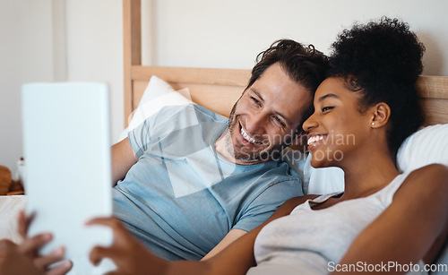 Image of Happy couple, smile and relax on bed for selfie, photo or morning post together at home. Interracial man and woman person smiling for fun profile picture, memory or vlog in bedroom at the house