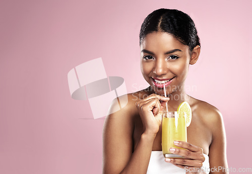 Image of Portrait, happy woman and orange juice drink in studio for healthy skincare, vitamin c benefits or mockup. African model, fruit cocktail and citrus smoothie of natural beauty, diet or pink background