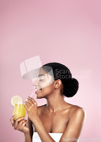 Image of Woman, healthy orange juice and smile in studio, pink background and mockup for vitamin c benefits. Happy african model, citrus smoothie and fruits for vegan nutrition, diet drink and natural beauty