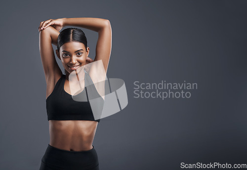 Image of Portrait, mockup and stretching with an athlete woman in studio on a gray background for fitness or health. Exercise, workout and warm up with an attractive young female model training her body