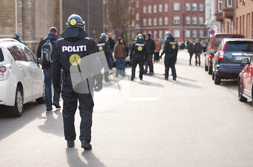 Image of Safety, riot and protest with police officer in city for law enforcement, protection or security. Brave, uniform and government with person in street for demonstration rally, human rights or activist