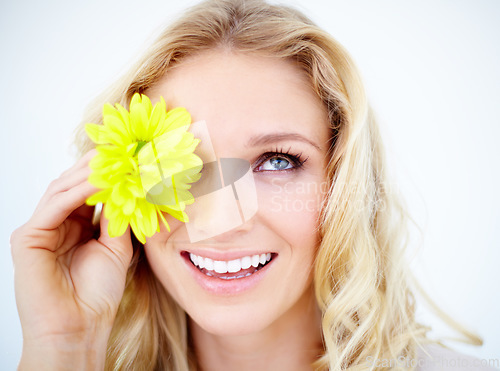 Image of Beauty, makeup and female model with a flower in studio with a cosmetic, natural and face routine. Happy, smile and closeup of young woman with yellow floral spring plant isolated by white background