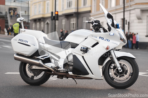 Image of Police, motorcycle and transportation vehicle in city, safety and law enforcement on urban road, empty street and Norway. Security, motorbike and travel for public service, legal power and authority