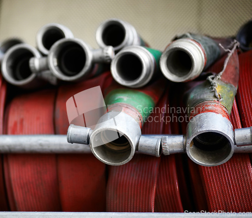 Image of Fire hose, firefighter or fireman equipment and safety or rescue. Metal or steel tools, behind the scenes of workplace and closeup of emergency red water pipes or gear for buildings and protection