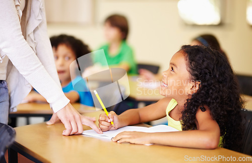 Image of Child, writing and hand of teacher teaching student at school for education, learning or development. Woman and happy girl with notebook, pencil and knowledge at classroom desk with support and smile