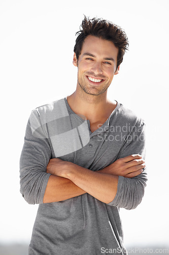 Image of Smile, portrait and man with arms crossed in nature for break, vacation or weekend in Spain. Happy, fashion and a handsome young guy smiling with confidence, happiness and relaxing on holiday