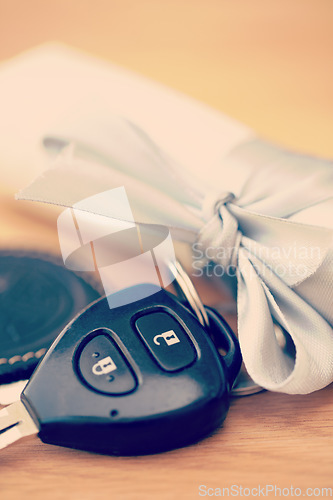 Image of Ribbon, present and keys for new car on table for surprise, gifts and birthday present for driver. Travel mockup, transport and closeup of vehicle key with bow for loan, motor investment and reward