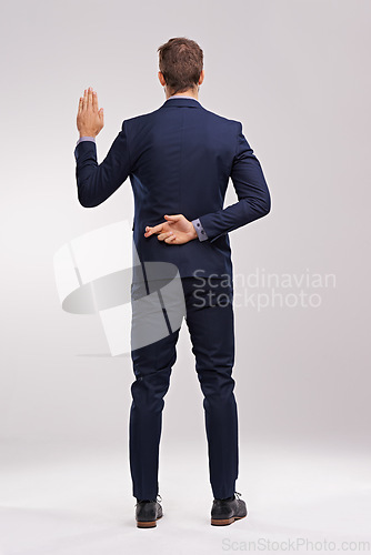 Image of Back of businessman, taking an oath and fingers crossed in a white background. Legal or court, cheat or corruption and dishonest man or liar with suit in studio backdrop with hand gesture for a lie