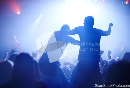 Image of Rock concert, celebration and party crowd with lighting and people back with dancing. Silhouette, audience and night festival event with performance and group listening and watching a band music