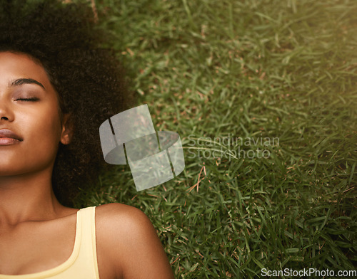 Image of Sleep, grass and mockup with a black woman lying on a field from above for peace or quiet outdoor in nature. Dreaming, relax and zen with an attractive young female resting alone in the countryside