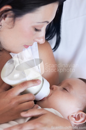 Image of Baby, feeding and mom with child at home with a bottle of milk with parent care with kids. Family, young youth and drink for growth and development with a mother feeling proud from childcare in house