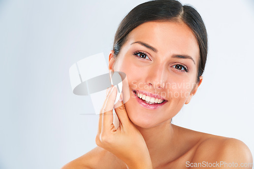 Image of Skincare, portrait and woman with a cotton pad in studio for a beauty, natural and face routine. Health, wellness and happy female model with health, wellness and cosmetic product by gray background.