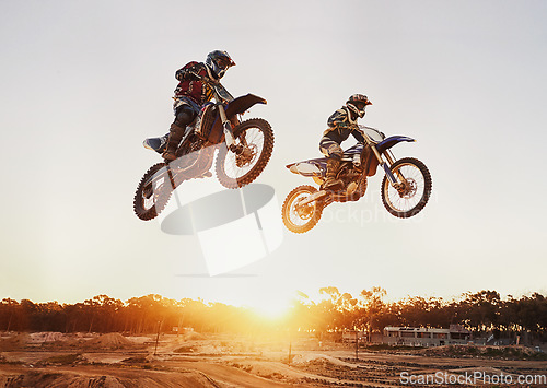 Image of Motorbike, jump and adventure during race for competition as transportation with sunset. Men, motorcycle and action for sports in the outdoor on fast course with power and moving fast with risk.