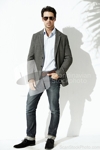 Image of Cool, sunglasses and portrait of a man with fashion isolated on a white background in a studio. Stylish, young and a model with confidence and fashionable clothes with shades and shadow on backdrop