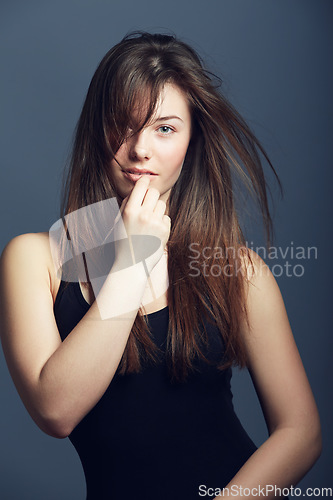 Image of Portrait, beauty and woman with hair care, volume and confident model against a dark studio background. Face, female person and girl with texture, cosmetics and hairstyle with growth and treatment