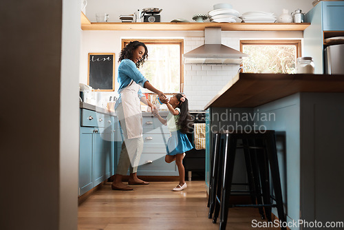Image of Happy, mother with child dancing in kitchen and at their home. Family with love, entertainment or comic and laughing female parent with daughter have fun together holding hands at their house